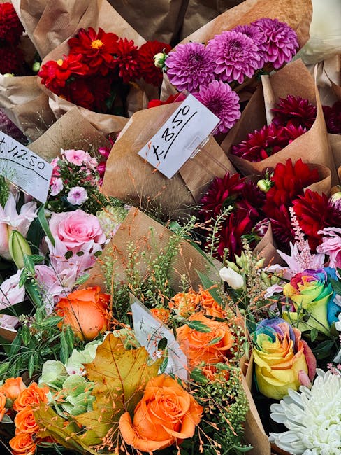 A vibrant display of freshly arranged floral bouquets on Erith High Street markets, featuring a variety of flowers including bright red dahlias and chrysanthemums, delicate pink roses and spray carnat